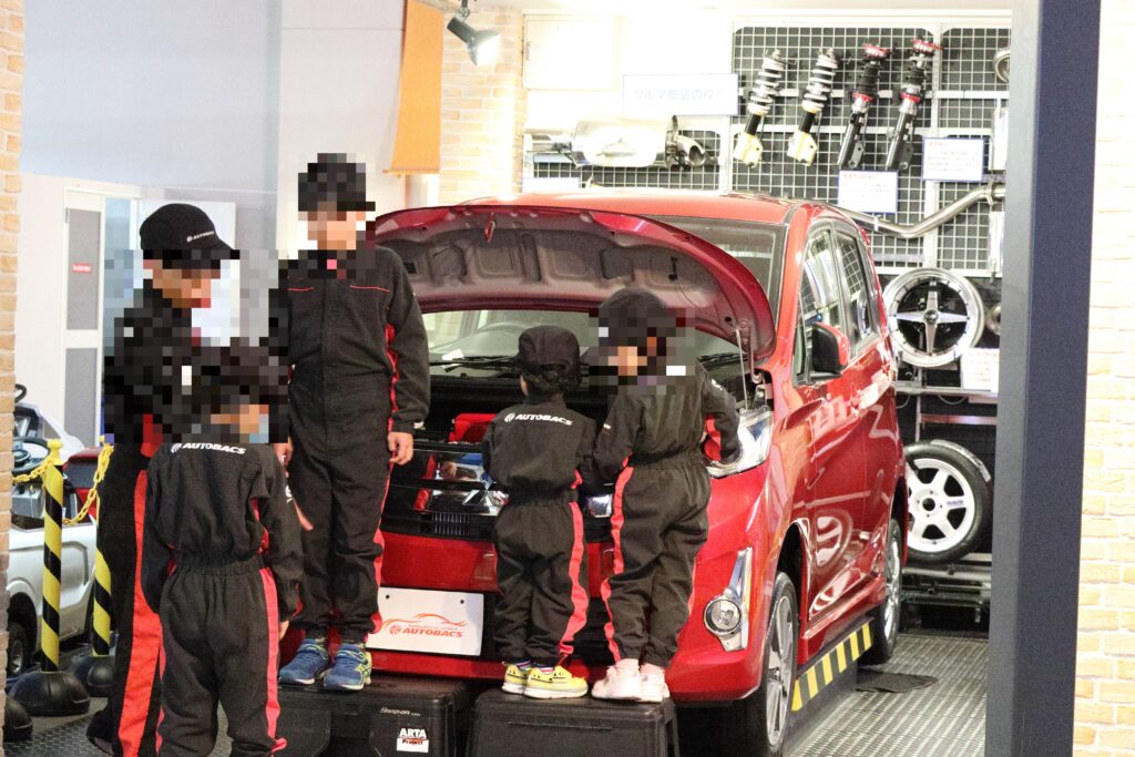 キッザニア東京のバッテリーチェックをする自動車整備士